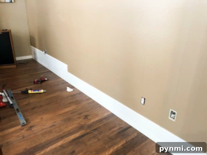 DIY Shiplap Accent Wall: Boards Being Installed on Living Room Wall Shiplap Wall Installation Progress Shot 1