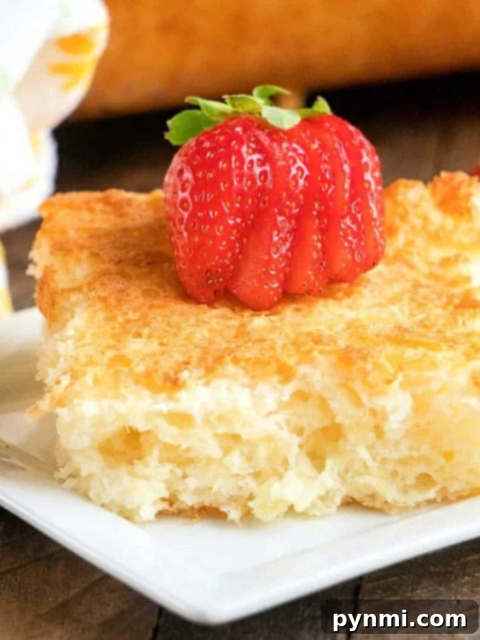 Heavenly Pineapple Delight 2 A slice of fluffy, golden pineapple angel food cake with a light texture, resting on a white plate.