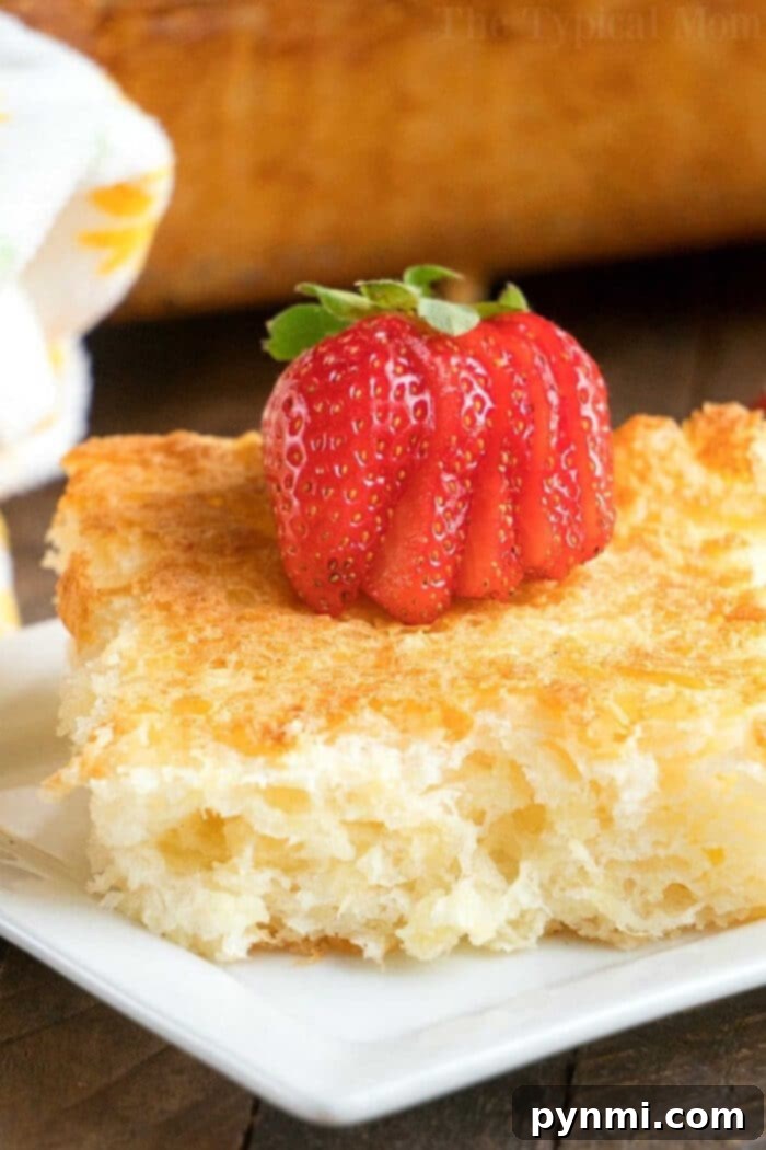 Heavenly Pineapple Delight 5 A slice of light and airy pineapple angel food cake, topped with fresh sliced strawberries, served on a white plate.