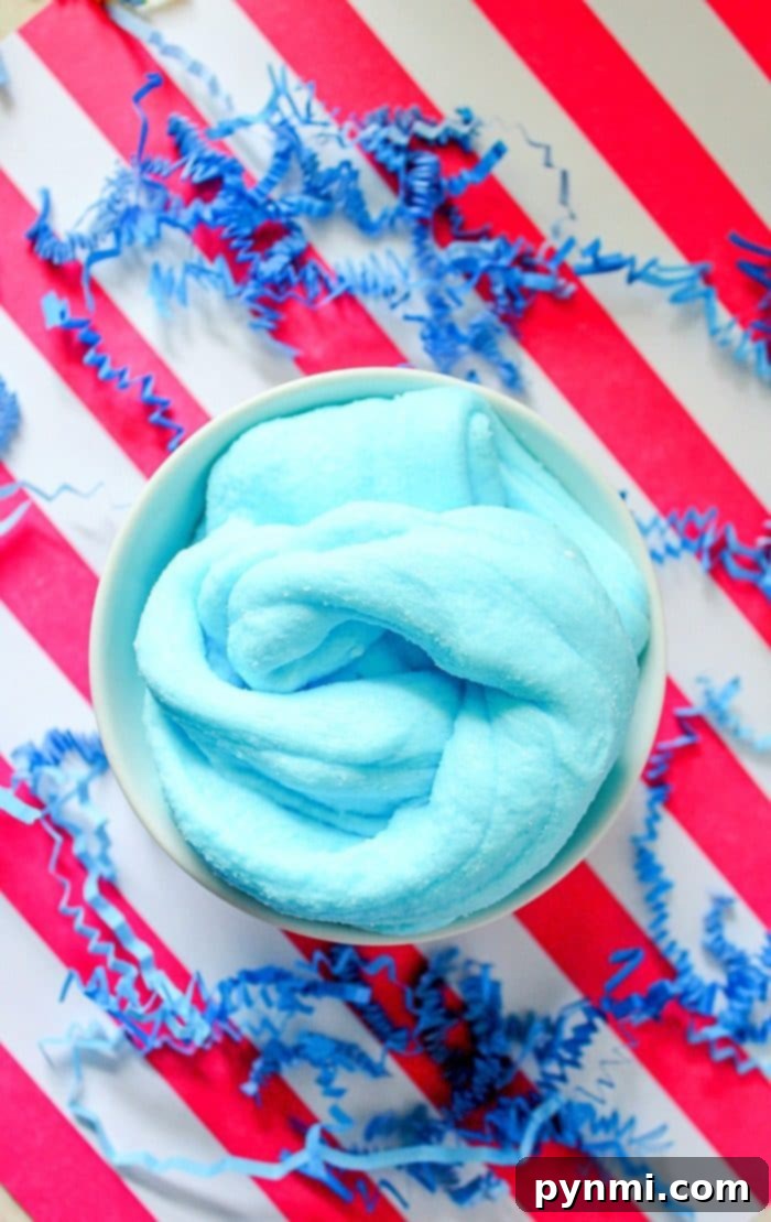Step-by-step guide: Mixing ingredients for your perfect scented slime creation. Hands mixing blue glue and liquid starch in a bowl, beginning the process of making homemade scented slime.