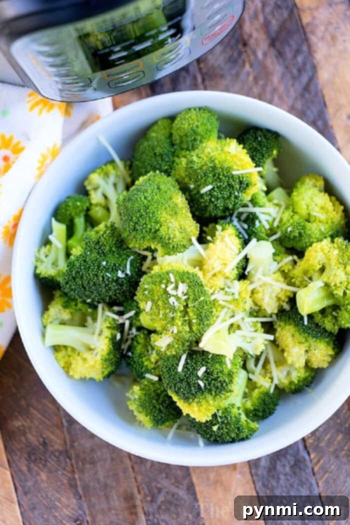 A large serving bowl filled with a variety of perfectly steamed vegetables, including vibrant broccoli florets.