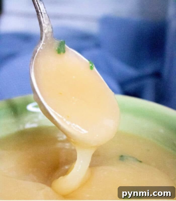 A spoon scoops up creamy, rich pressure cooker gravy, highlighting its smooth texture and appetizing appearance.