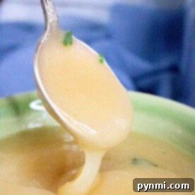 A spoon scoops up creamy rich pressure cooker gravy.