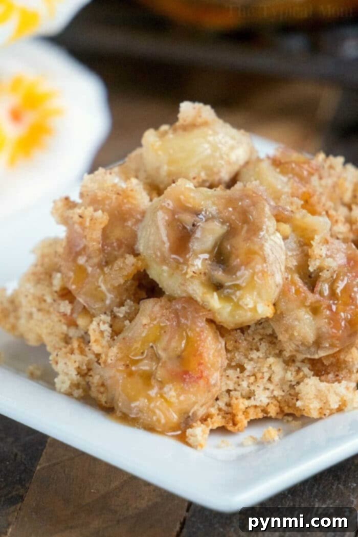 Easy Banana Dump Cake: A simple, delicious dessert reminiscent of banana bread, topped with caramel sauce. Close-up of a delectable banana dump cake, showcasing perfectly caramelized banana slices on a square white plate, ready to be enjoyed.