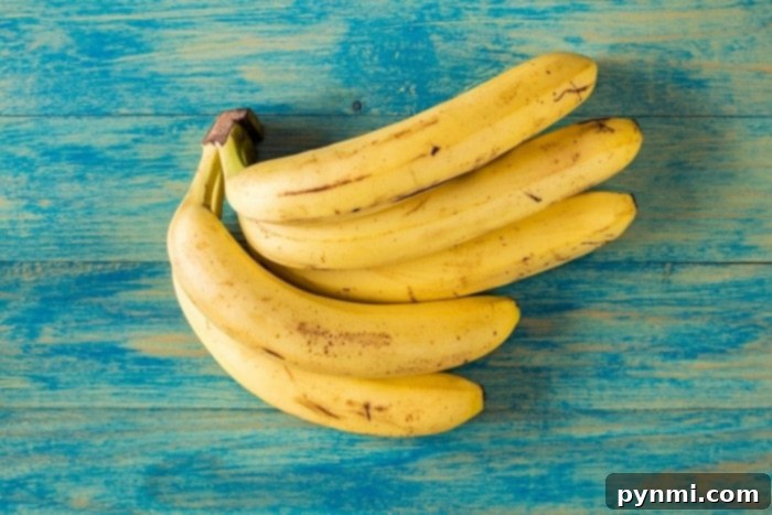 Close-up of a bunch of ripe bananas, some with brown spots, ideal for making banana bread.