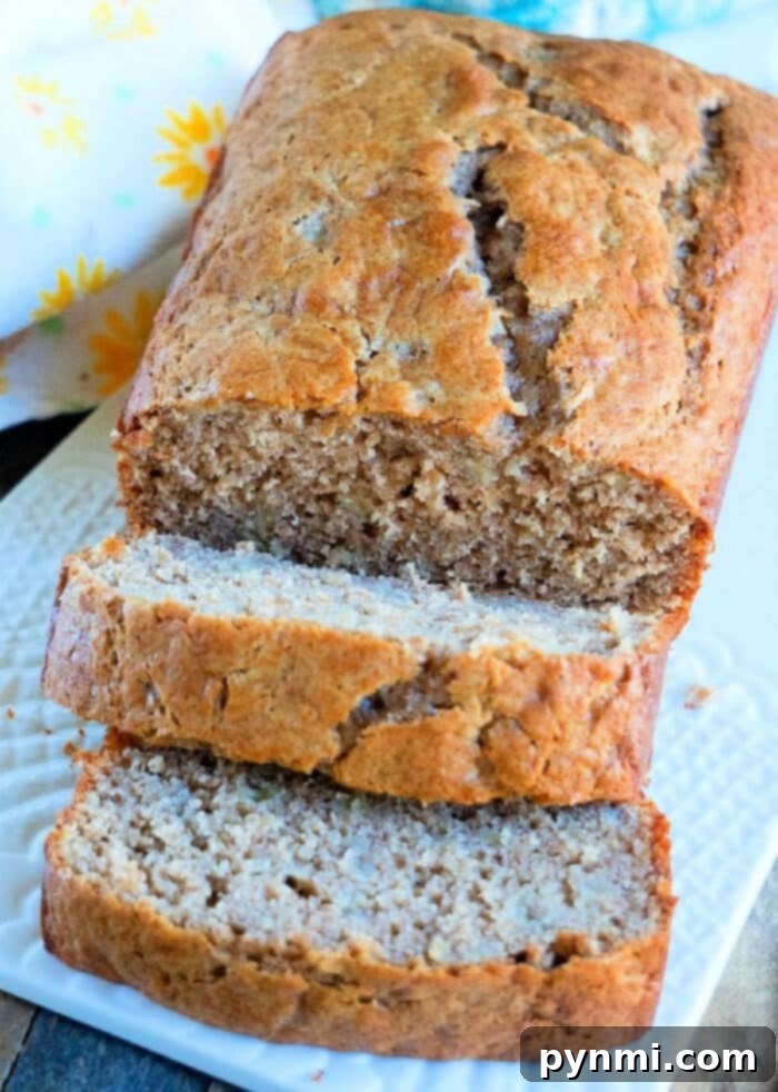 Two loaves of freshly baked cake mix banana bread, one whole and one sliced, presented on a wooden board.