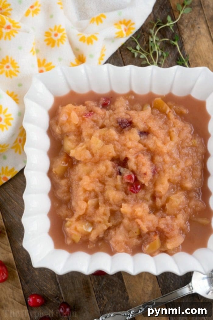 This Instant Pot cranberry applesauce is a great Thanksgiving or Christmas side dish or snack throughout the year. It's a great sweet homemade treat. #instantpot #instantpotrecipes #thetypicalmom #cranberry #applesauce #homemade #pressurecooker #crockpotexpress cranberry applesauce in a mason jar