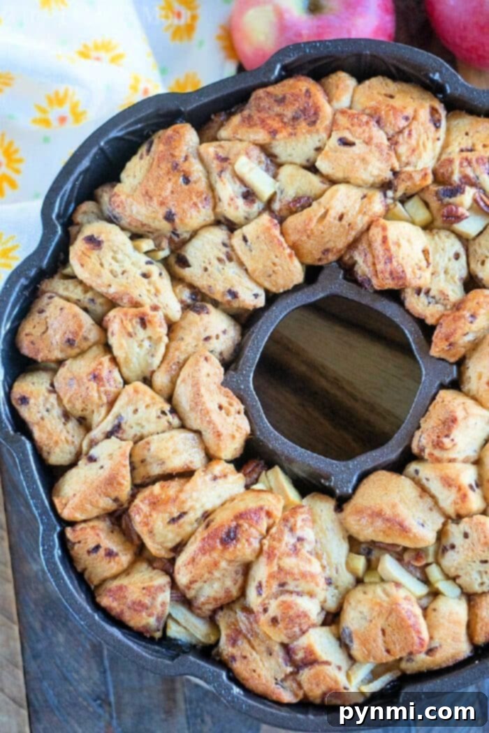 This apple monkey bread is packed full of fresh apples and really delicious! The best monkey bread I've made with refrigerated cinnamon rolls ever. #monkeybread #apple #breakfast #cinnamonroll #best #thetypicalmom Easy Apple Monkey Bread recipe, inverted from a bundt pan and drizzled with icing.