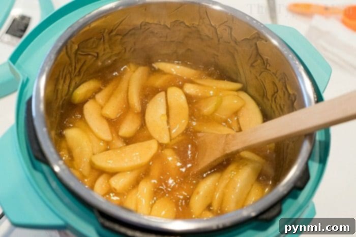 A close-up shot of rich, glossy homemade apple pie filling, showcasing its perfect texture and apple chunks.