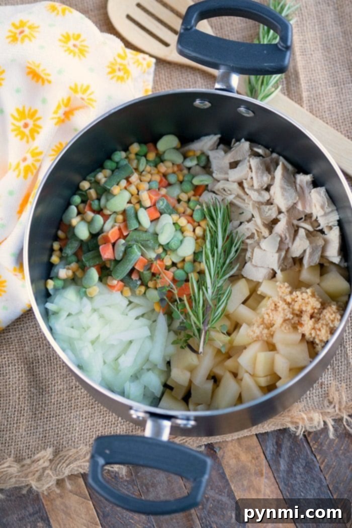 A close-up shot of creamy turkey pot pie soup in a pot, highlighting the rich broth and colorful vegetables, ready to be served.