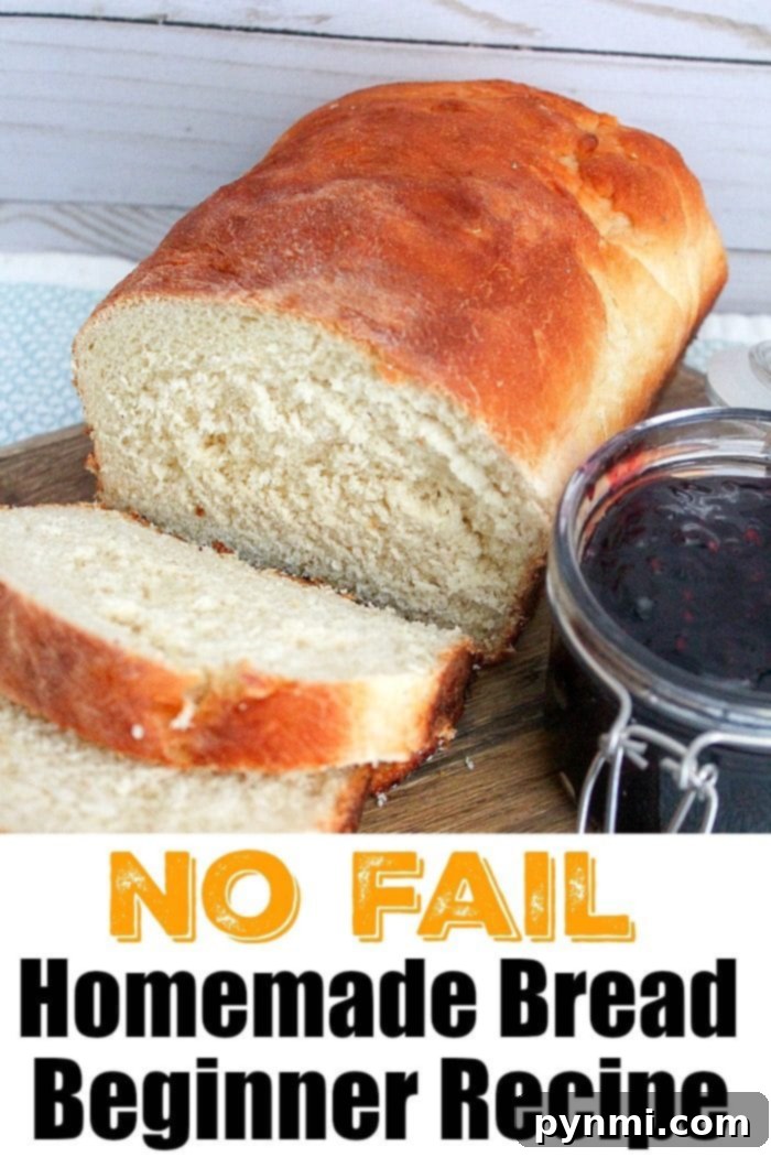 A beautifully baked loaf of homemade bread with one slice cut, next to a jar of jam. Text reads: No Fail Homemade Bread Beginner Recipe for baking bread at home.