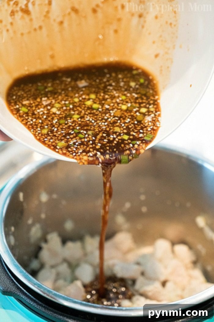 Instant Pot sesame chicken served over rice with green onions