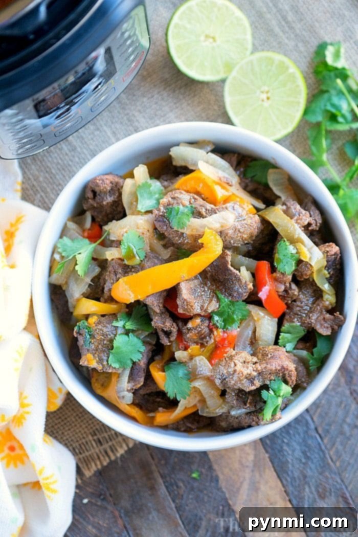 Instant Pot steak fajitas platter with all the fixings: tortillas, salsa, sour cream, and avocado