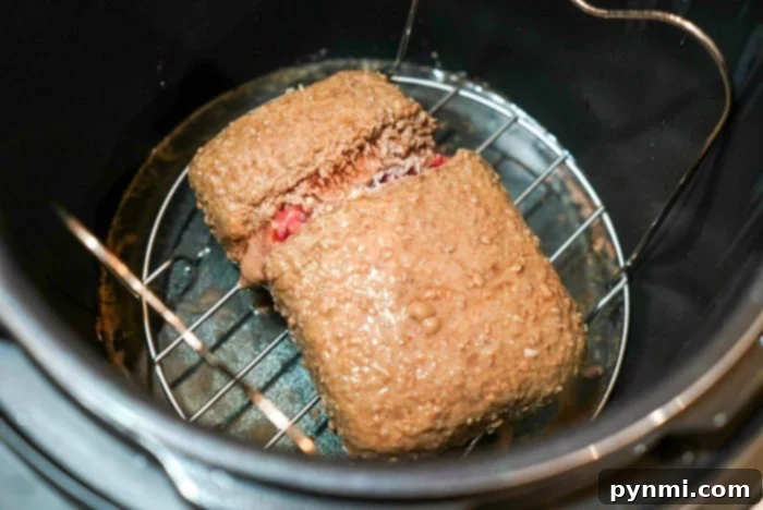 Thawed and lightly browned ground beef on a trivet inside an Instant Pot, ready for further cooking.