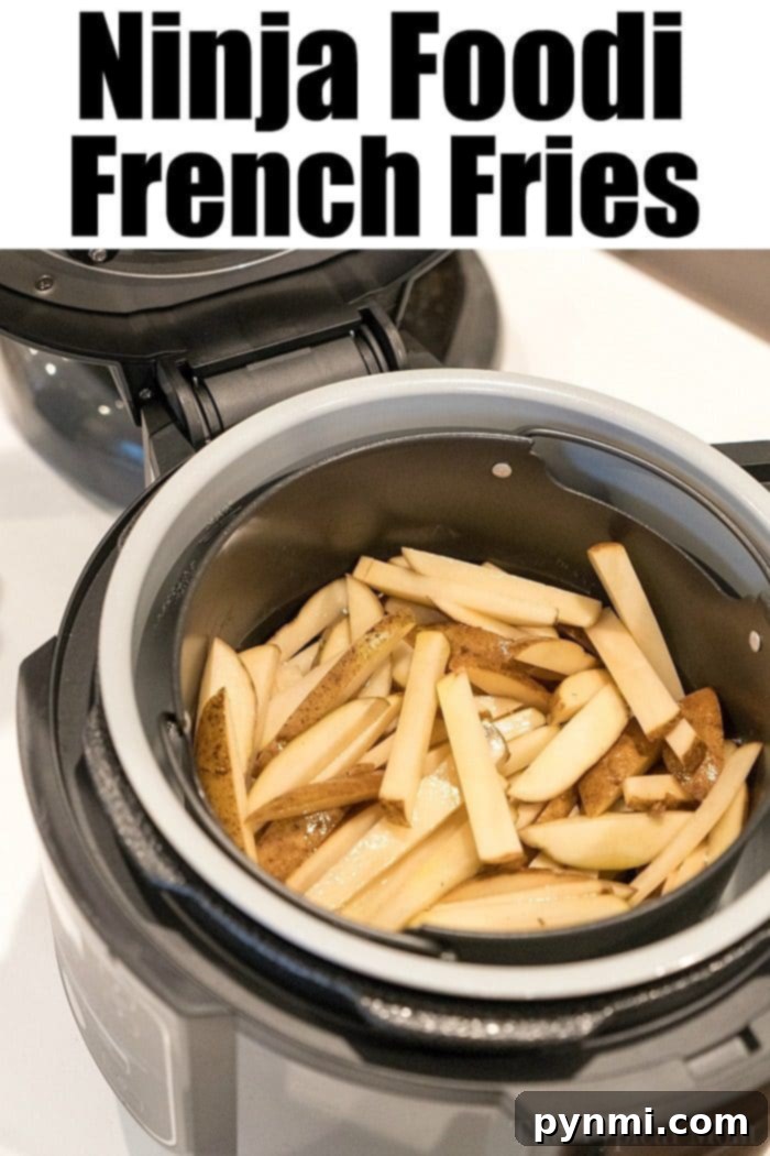 Perfectly Crispy Ninja Foodi Fries 6 A pristine white cutting board holds a pile of freshly sliced potatoes, perfectly shaped into French fries, awaiting seasoning and air-frying in the Ninja Foodi.