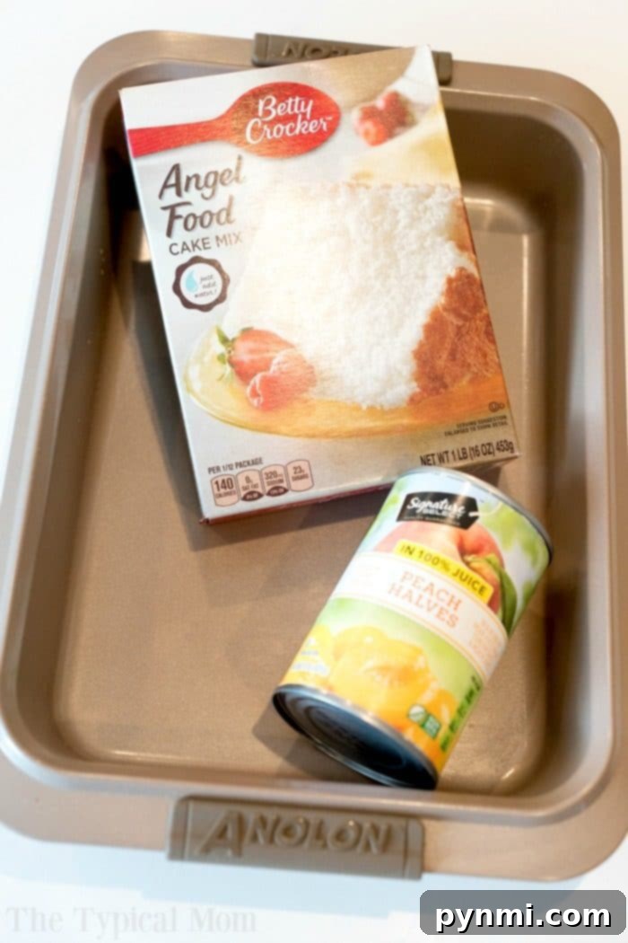 2-Ingredient Peach Angel Food Dump Cake in 9x13 Pan A second view of the Peach Angel Food Cake, still in its 9x13 baking dish, showcasing its golden-brown top and the luscious peach pieces baked within. This image highlights the cake's ease of preparation, emphasizing that no special tube pan is required for this fat-free dump cake recipe.
