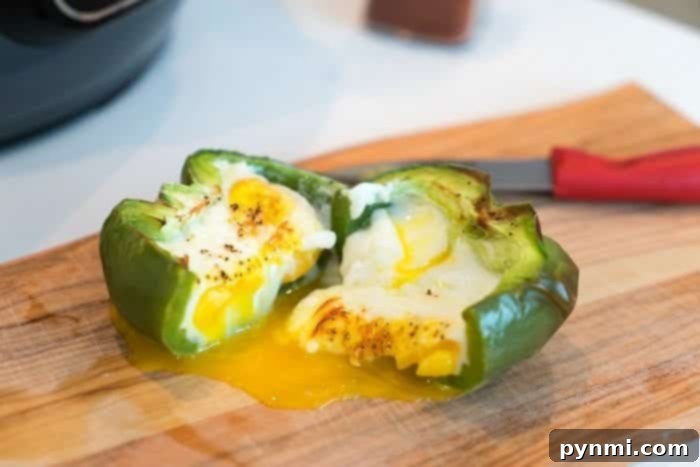 Air fryer breakfast stuffed peppers are the perfect low carb start to the day! A tender bell pepper filled with eggs you can eat on the go & enjoy today. #airfryerrecipes #airfryer #breakfast #eggs #peppers #stuffedpeppers #ninjafoodirecipes #ninjafoodi #thetypicalmom air fryer breakfast