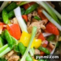 A vibrant instant pot stir fry featuring snap peas, bell peppers, juicy chicken, and fresh green onions.