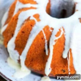 Bundt cake with white icing drizzled on top, crafted to perfection in a Ninja Foodi, served elegantly on a white plate.