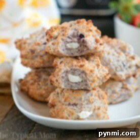 A plate of blueberry bagel bites with cream cheese filling sits temptingly beside a basket of 2 Ingredient Air Fryer Bagel Bites, creating a delightful spread for any occasion.