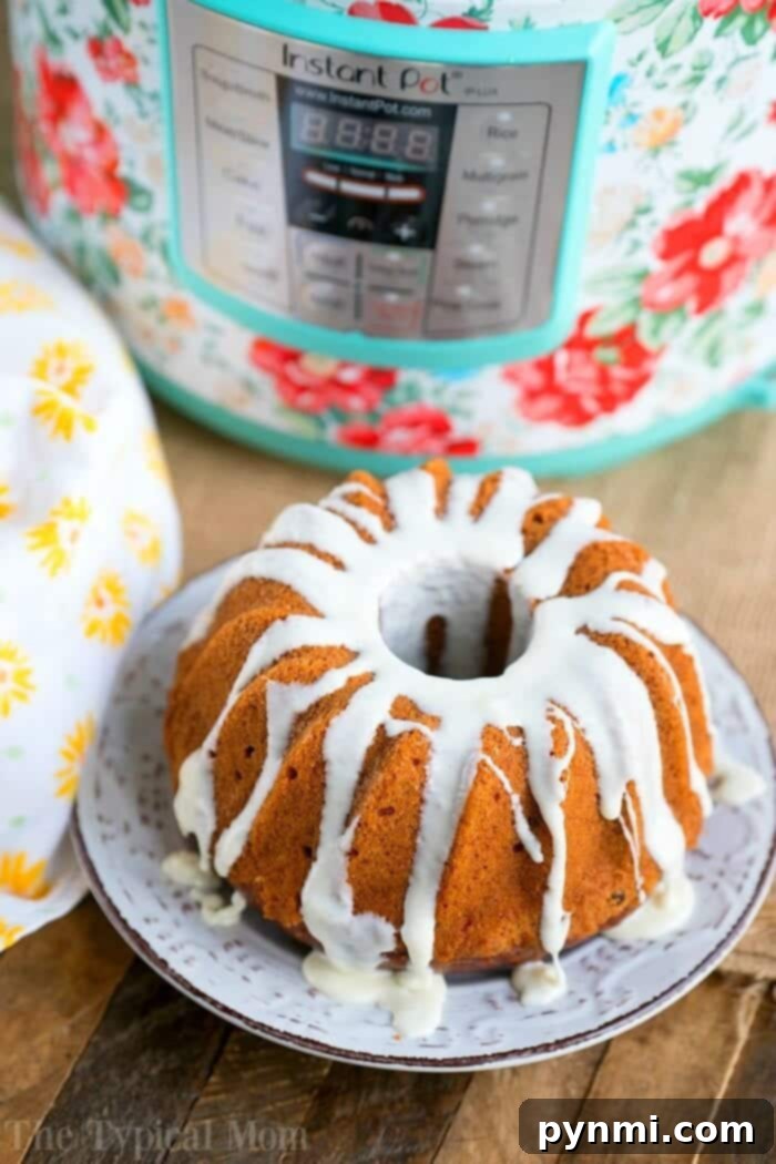 Close-up of a slice of Instant Pot Carrot Cake with cream cheese frosting, showcasing its delicious texture.