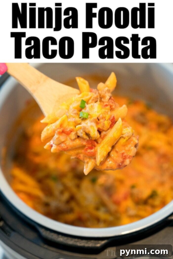 A bowl of creamy, cheesy Ninja Foodi Taco Pasta, garnished with fresh herbs.