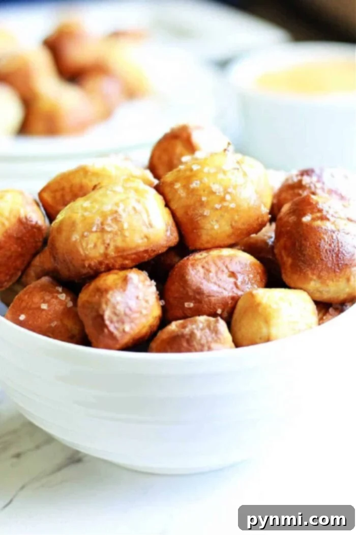 Golden brown air fryer pretzel bites scattered on a surface, ready to be enjoyed.