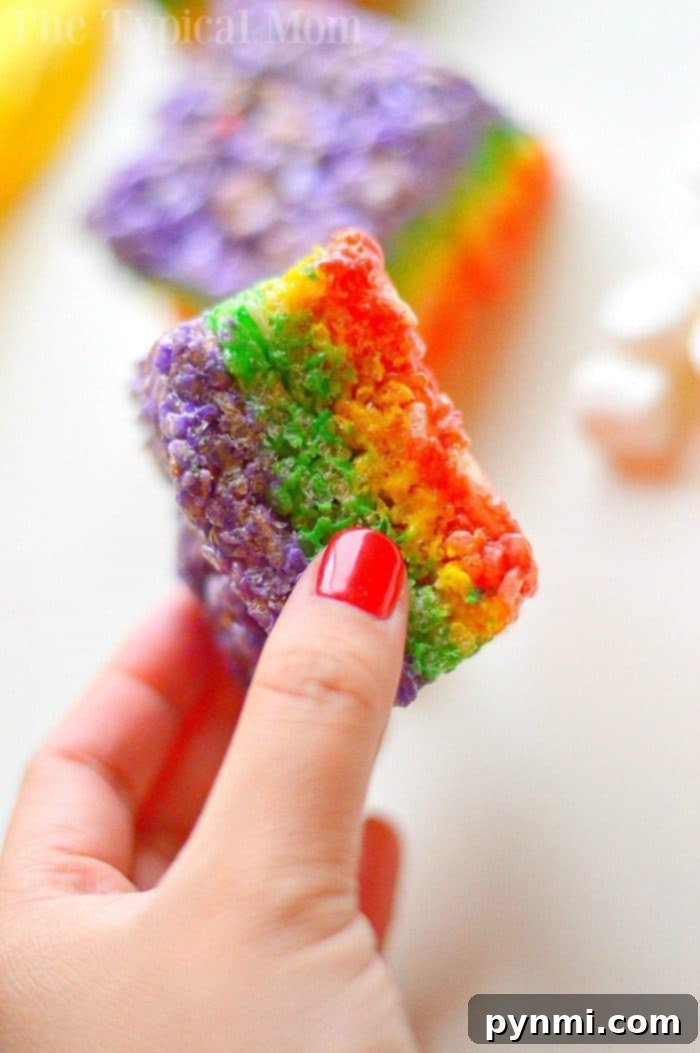 Delicious rainbow marshmallow squares, layered with colorful marshmallows and a sweet, gooey base, perfect for a party dessert.