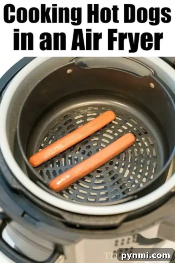 Air Fryer hot dogs or chili dogs are the perfect quick dinner idea our whole family loves! Load your buns up with toppings & they come out nice & crispy. #airfryer #hotdogs #chilidogs #ninjafoodi #ninjafoodirecipes Two uncooked hot dogs precisely placed inside an air fryer basket, ready for cooking.