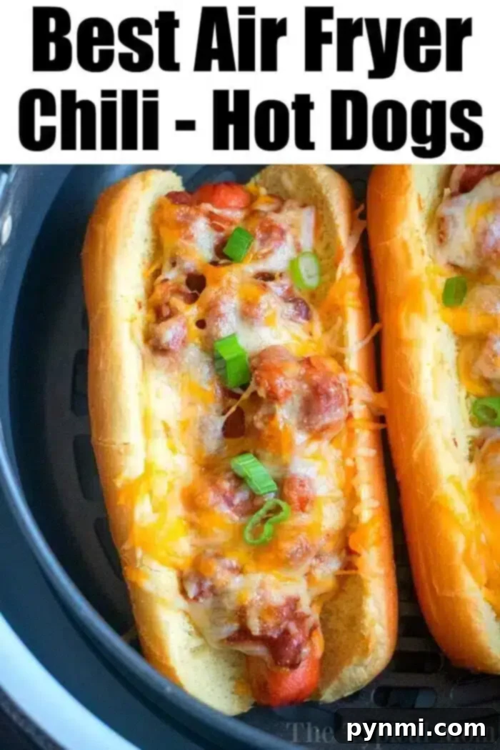 Air Fryer hot dogs or chili dogs are the perfect quick dinner idea our whole family loves! Load your buns up with toppings & they come out nice & crispy. #airfryer #hotdogs #chilidogs #ninjafoodi #ninjafoodirecipes Close-up of two chili cheese hot dogs, perfectly golden and topped with melted cheese and fresh green onions, ready to serve.