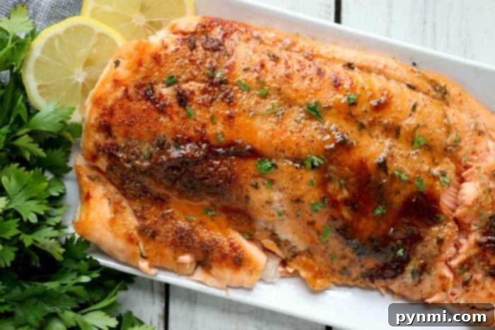 Air Fryer Salmon: Your Easiest Dinner Yet 7 Dry rub salmon fillet with herbs and lemon slices on a white plate after air frying.