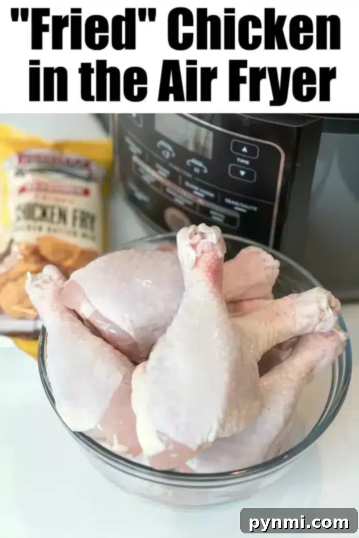 Preparing Chicken for Air Frying: Ingredients and Setup A glass bowl filled with raw chicken drumsticks ready for seasoning, placed in front of an air fryer. A package of 'Chicken Fry' mix is visible in the background, signaling the ease of this air fryer fried chicken recipe. The scene emphasizes preparation for a healthier fried chicken alternative.