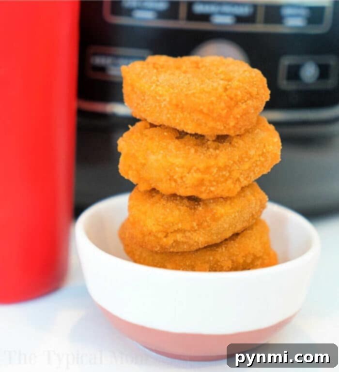 A close-up of golden, crispy frozen chicken nuggets, perfectly cooked in an air fryer and ready to be served.