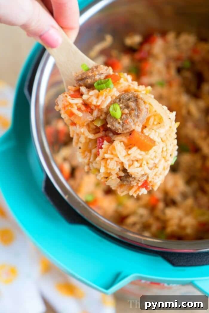 A close-up shot of a pot of pressure cooker jambalaya, with rice, sausage, and bell peppers visible