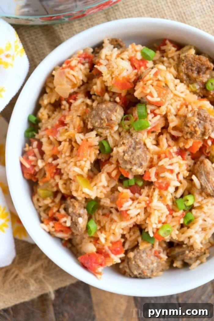 A close-up of a serving of steaming hot pressure cooker jambalaya, showing the vibrant mix of rice, sausage, and vegetables