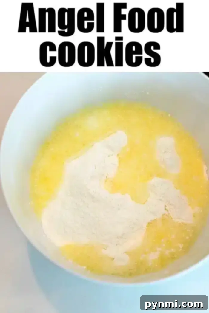 A white mixing bowl containing yellow, melted butter and white, powdered ingredients.