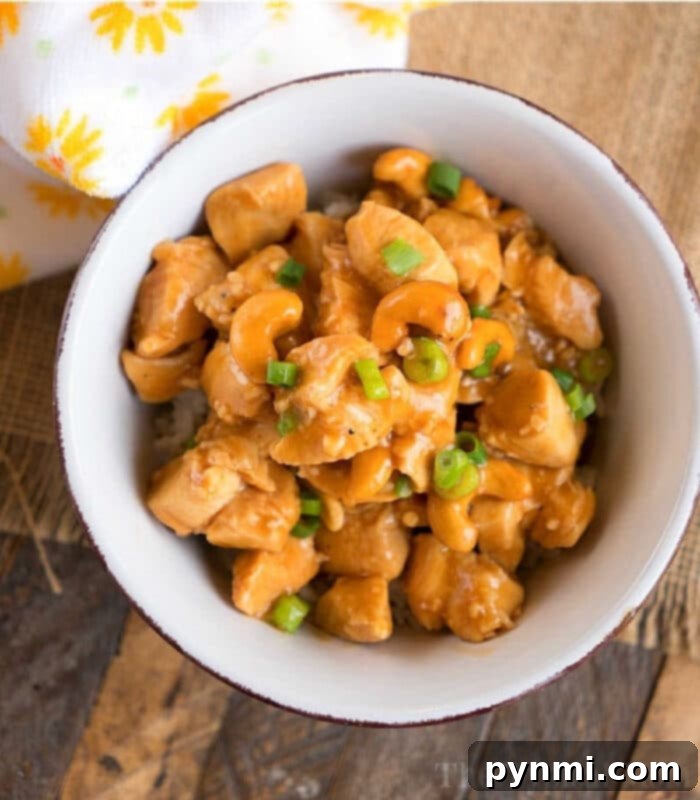 A vibrant bowl of Pressure Cooker Cashew Chicken, garnished with fresh green onions and sesame seeds, ready to be served over rice.