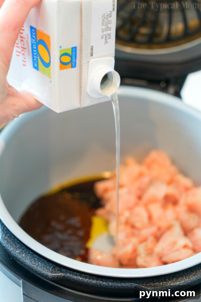 Overhead shot of a Ninja Foodi pressure cooker with cooked chicken and cashews inside, ready to be served.