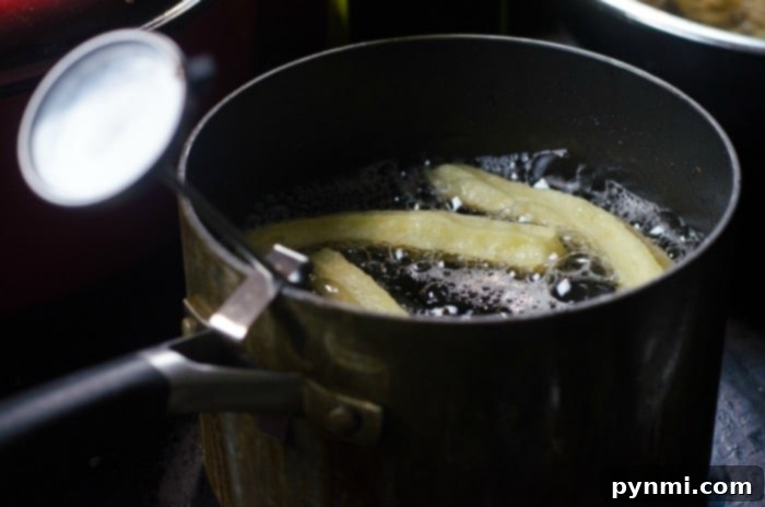 Homemade Churros Heaven 3 churros sizzling deliciously in a pot of oil on the stovetop, crafting the best homemade churros recipe