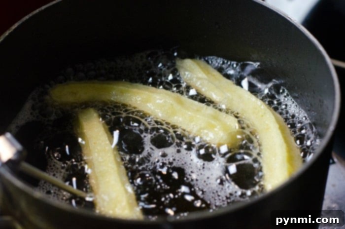 Homemade Churros Heaven 4 churros frying in hot oil inside a pan for the best churros recipe