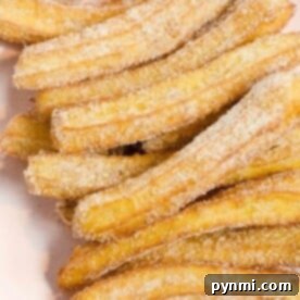 A plate of sugar-coated churros, crafted from the best churros recipe, stacked together.