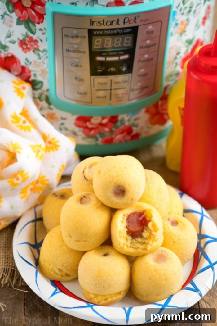 Instant Pot corn dog bites are easy to make in your Instant Pot, Crock Pot Express or Ninja Foodi! The perfect snack or lunch your kids will love. #instantpotrecipes #instantpot #ninjafoodi #ninjafoodirecipes #corndogs #eggmold #pressurecooker #snacks #lunch #corndogbites A vibrant close-up of finished Instant Pot corn dog bites arranged on a plate with dipping sauces.