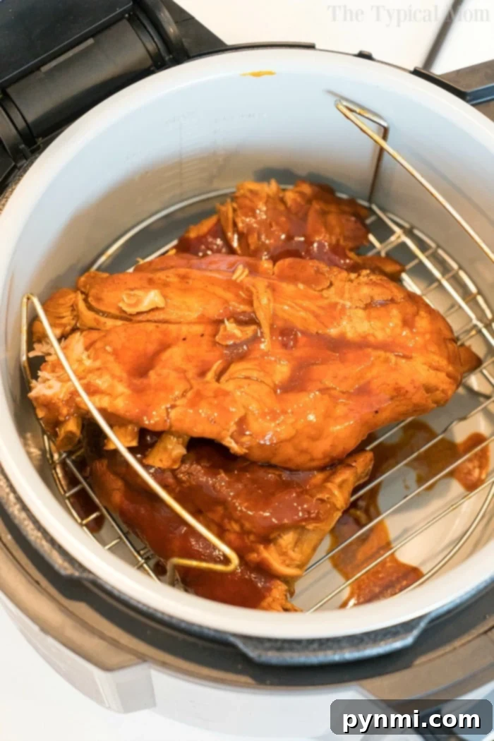 Delicious pressure cooker ribs fresh out of the Ninja Foodi, before the air crisping stage, showing their tender, cooked state.