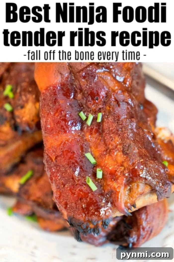 Close-up of three pieces of succulent Ninja Foodi ribs covered in a thick, glossy barbecue sauce, ready to be served.
