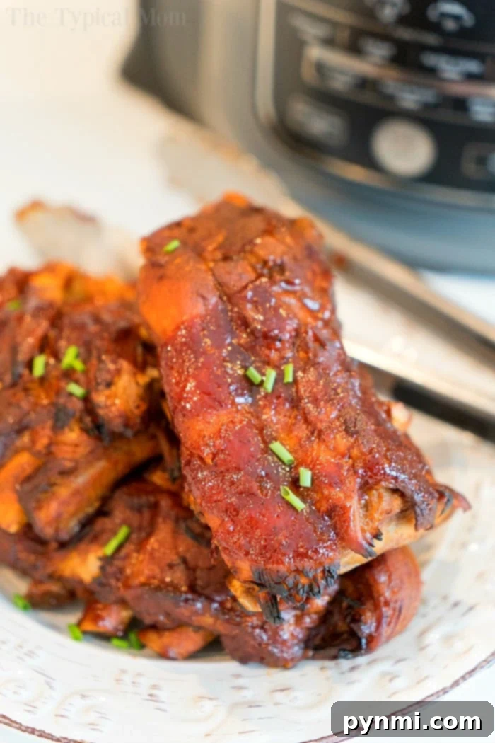 A close-up shot of a single piece of Ninja Foodi pork rib, showing its tender interior and crispy, sticky exterior and glistening glaze.