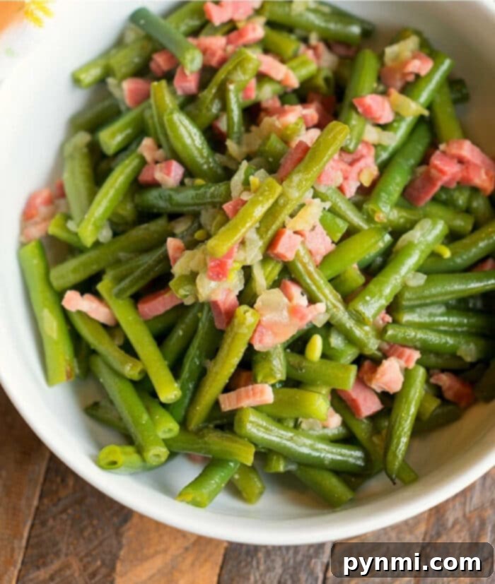 A bowl of perfectly sautéed green beans, enhanced with diced bacon and onions, expertly prepared in a Ninja Foodi.