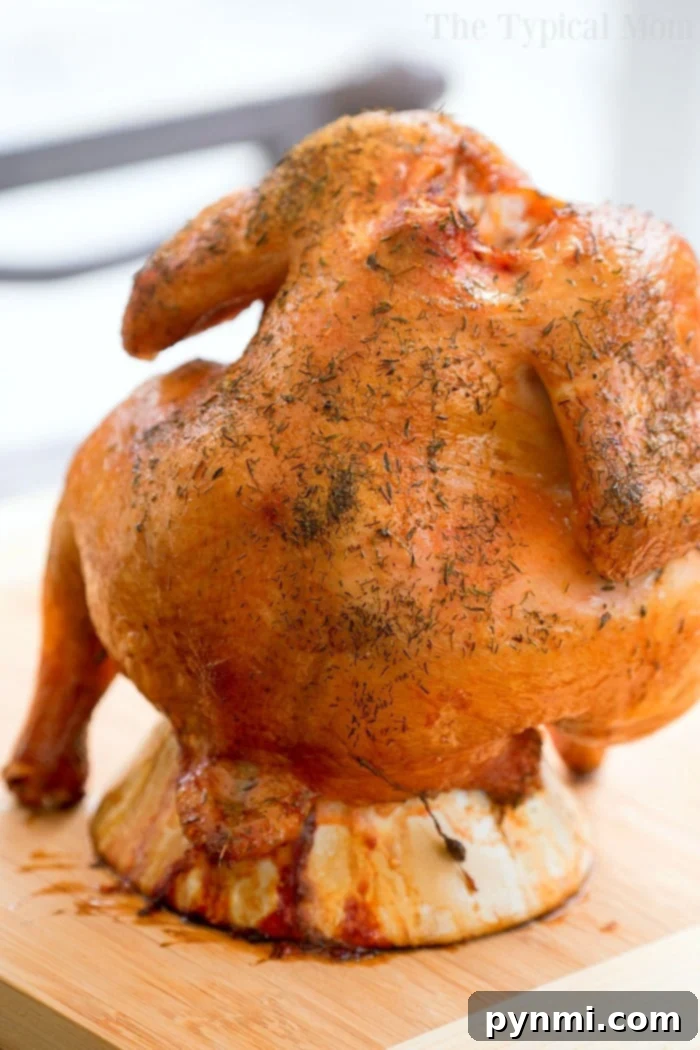 Smoked Beer Can Chicken 2 - A golden-brown, beautifully smoked chicken carved and presented on a wooden board.