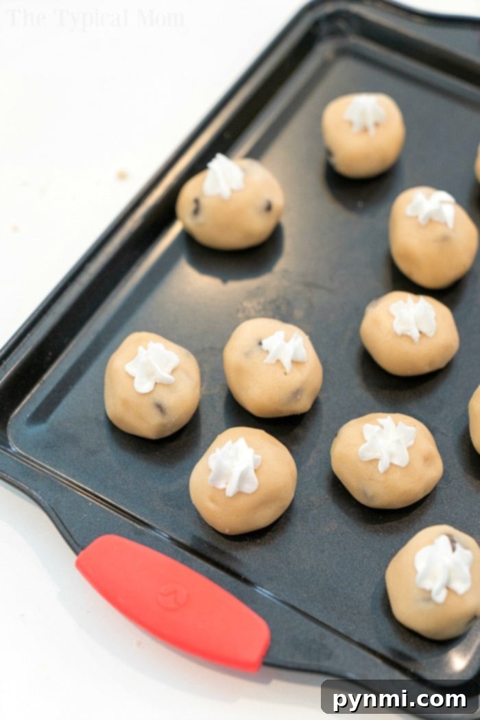 A colorful array of edible raw cookie dough balls, some frosted, arranged beautifully on a plate, ready to be enjoyed.