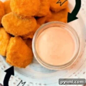 Chicken nuggets next to a small bowl of fry sauce on a white plate. Perfect for those wondering how to make that ultimate dipping delight!