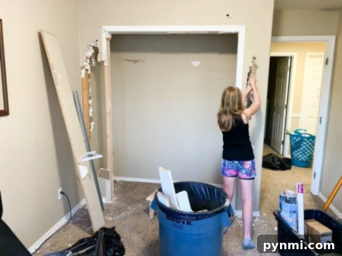 Progress shot showing the opened wall and framing for the new closet entrance.
